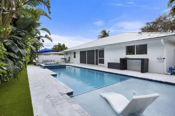 a view of a white house with a swimming pool