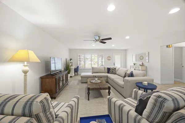 a living room with furniture a lamp and a flat screen tv
