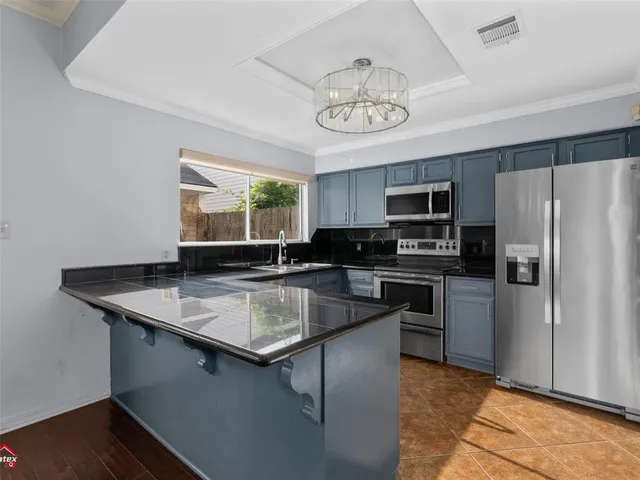 a kitchen with stainless steel appliances granite countertop a sink refrigerator stove and microwave