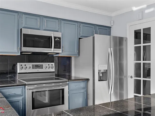 a kitchen with stainless steel appliances a stove a microwave and a refrigerator