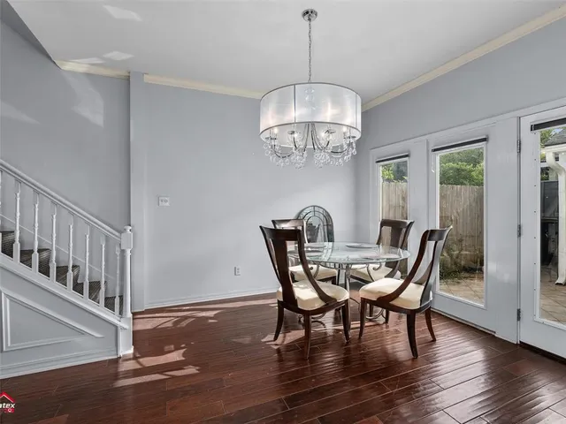 a view of a dining room with furniture a chandelier and wooden floor