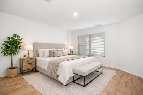 a bedroom with a large bed and a potted plant