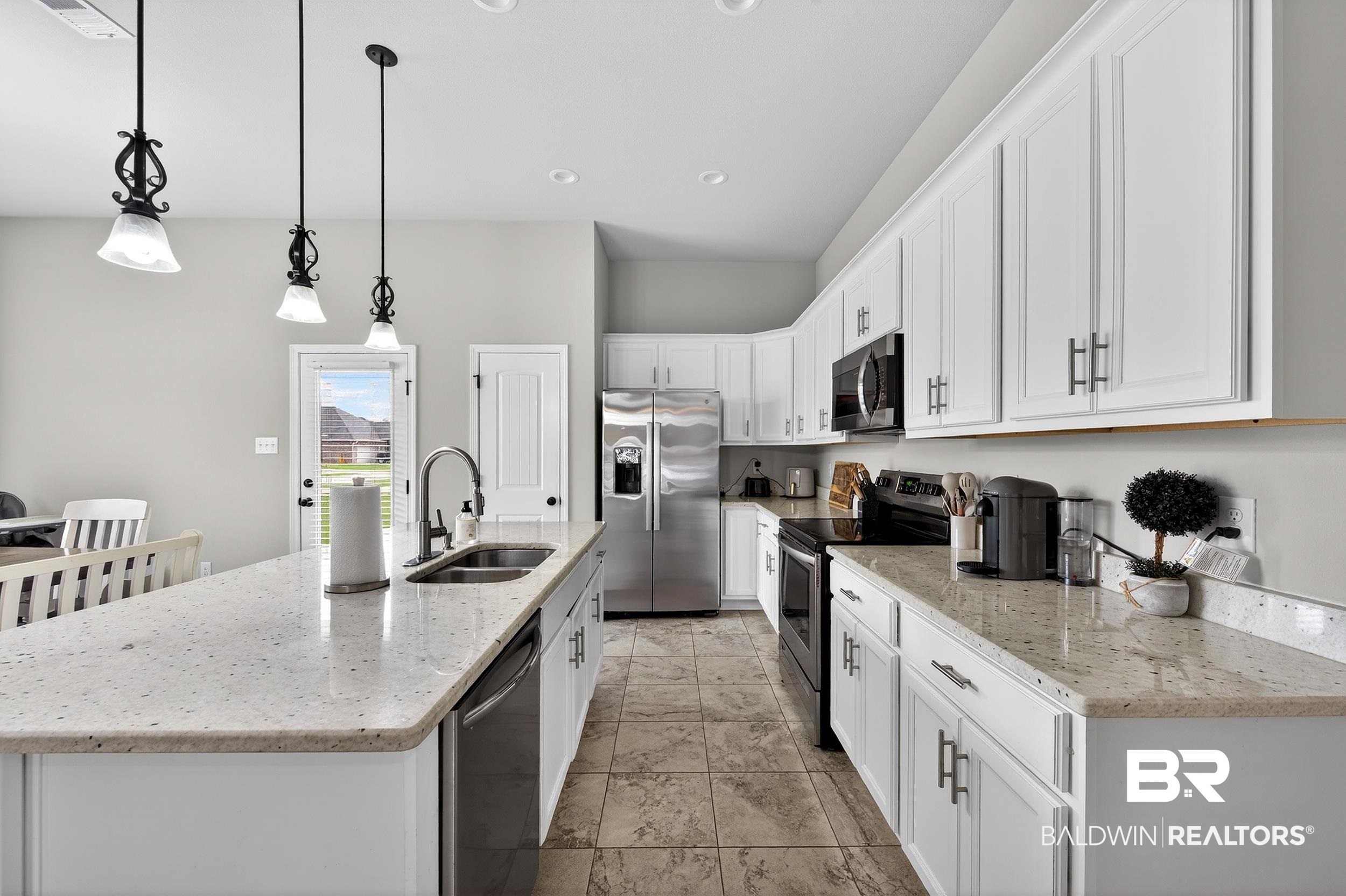 1084 Stella Road Foley, AL 36535 - Photo 13 of 31 Kitchen with light stone counters, stainless steel appliances, a center island with sink, and white cabinets