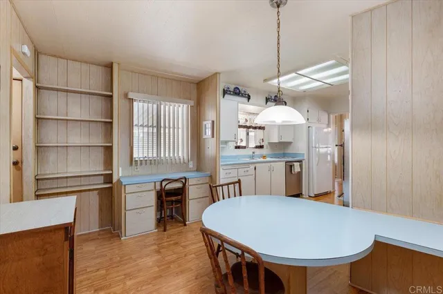 a kitchen with a table chairs sink and cabinets