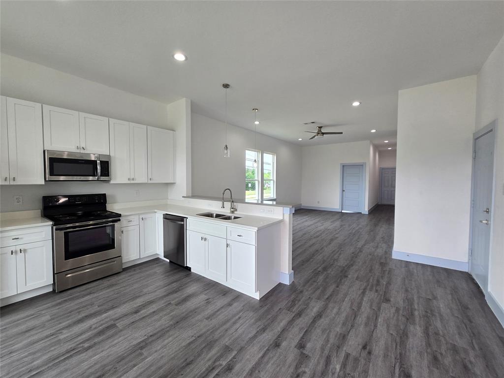 3202 Noor Street Dallas, TX 75233 - Photo 3 of 20 a large kitchen with cabinets wooden floor and stainless steel appliances