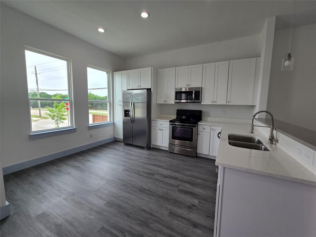 3202 Noor Street Dallas, TX 75233 - Photo 5 of 20 a kitchen with stainless steel appliances granite countertop a refrigerator a sink dishwasher a stove with wooden floors and cabinets