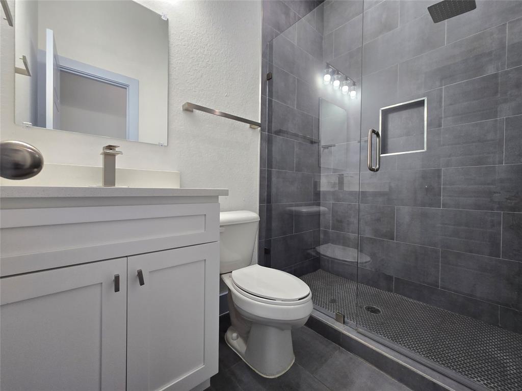 3202 Noor Street Dallas, TX 75233 - Photo 9 of 20 a bathroom with a shower a toilet and sink