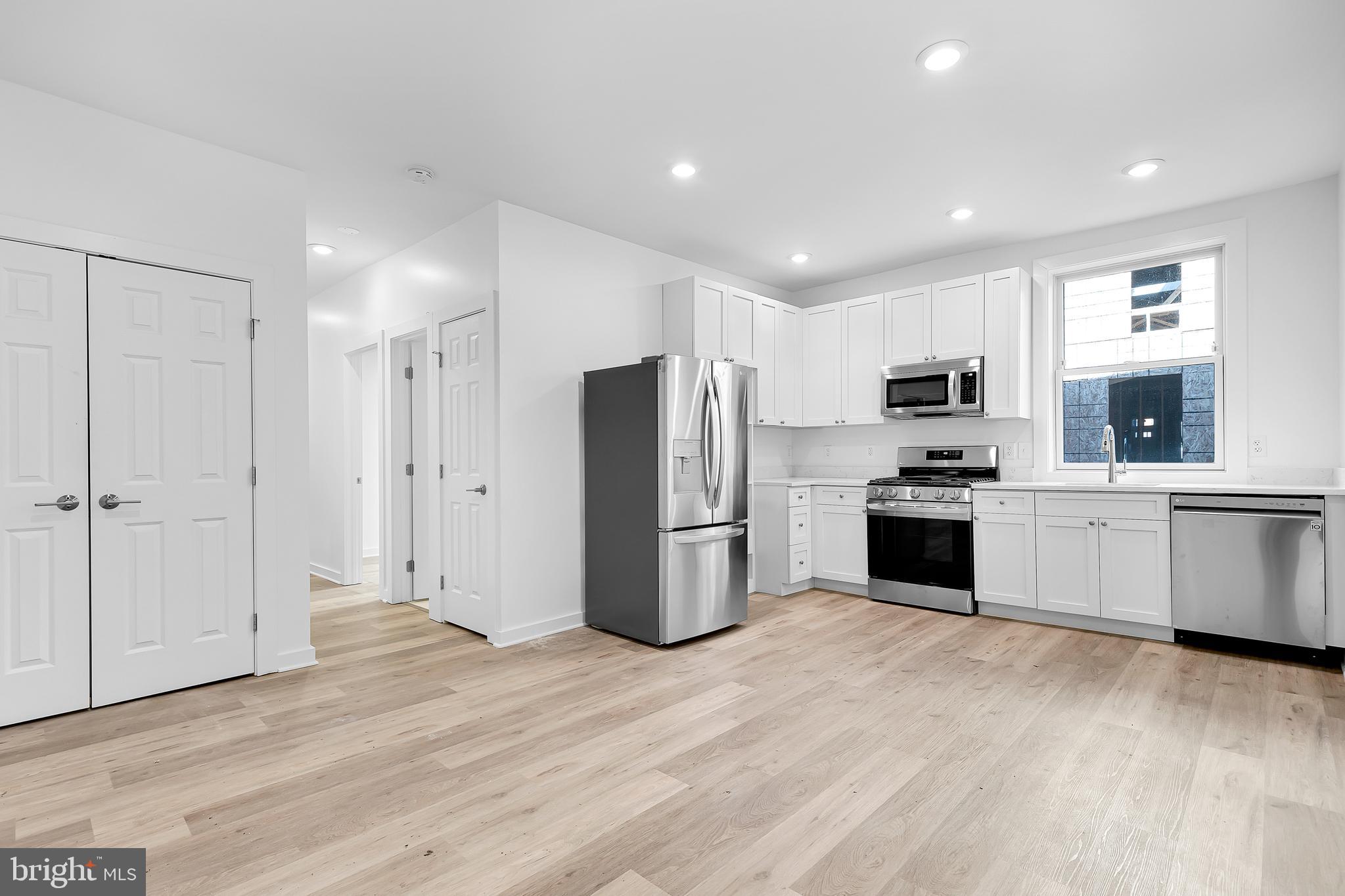 1712 3rd Street Northwest Washington, DC 20001 - Photo 2 of 32 a kitchen with white cabinets and stainless steel appliances