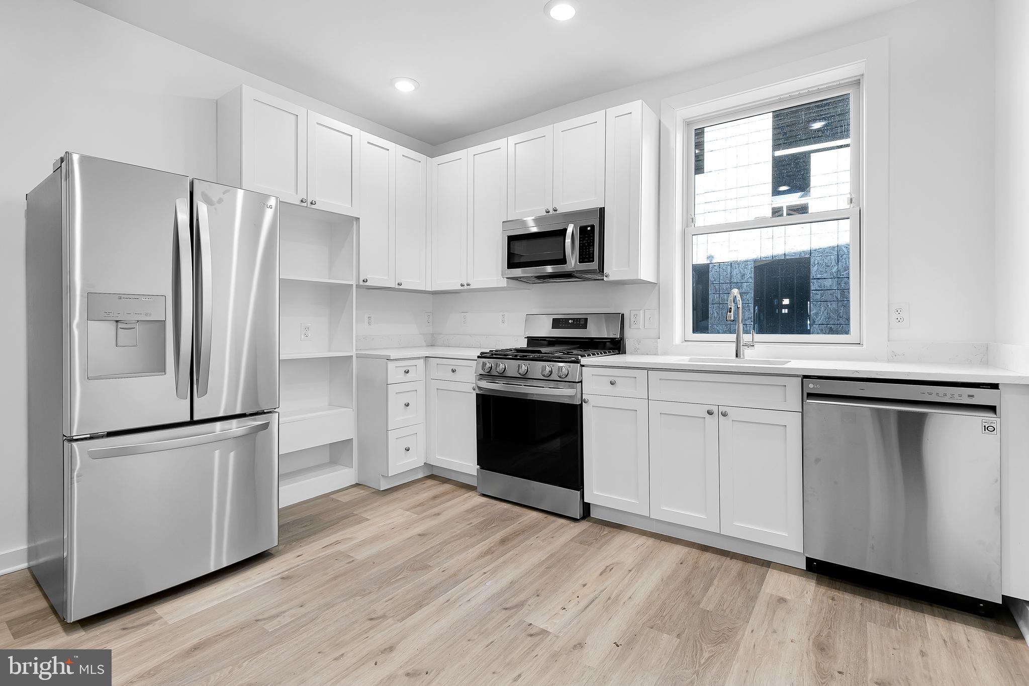 1712 3rd Street Northwest Washington, DC 20001 - Photo 3 of 32 a kitchen with white cabinets and stainless steel appliances