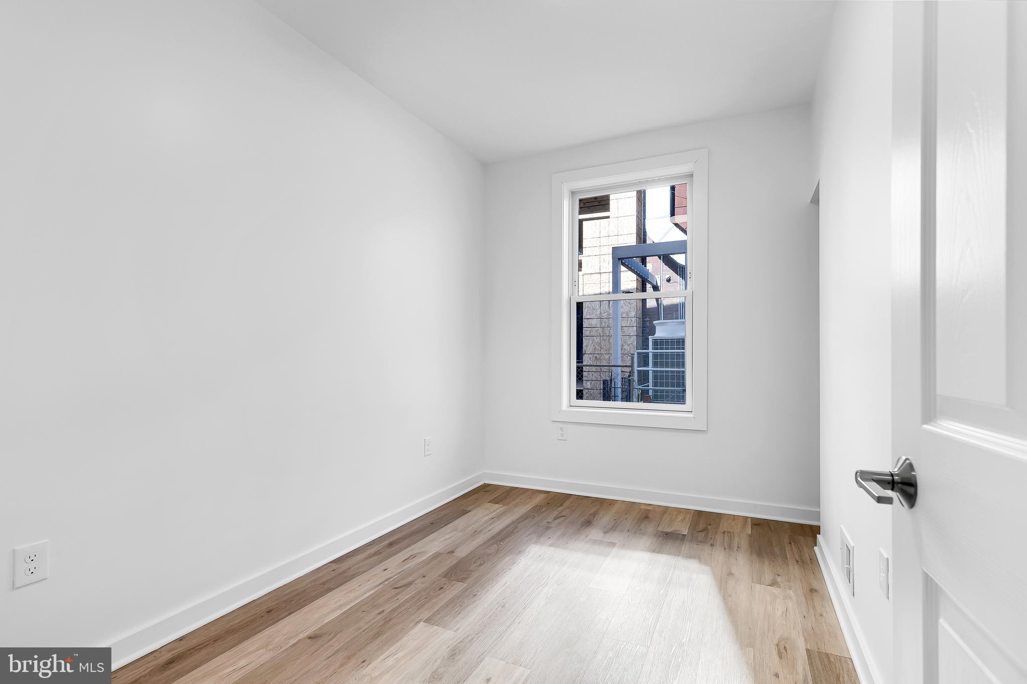 1712 3rd Street Northwest Washington, DC 20001 - Photo 7 of 32 a view of an empty room with wooden floor and a window