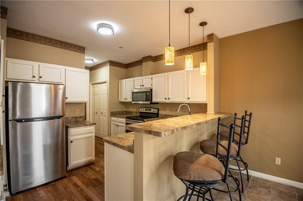 23 Stone Ridge Boulevard Hermitage, PA 16148 - Photo 7 of 23 a kitchen with stainless steel appliances a refrigerator a stove a sink and white cabinets with wooden floor
