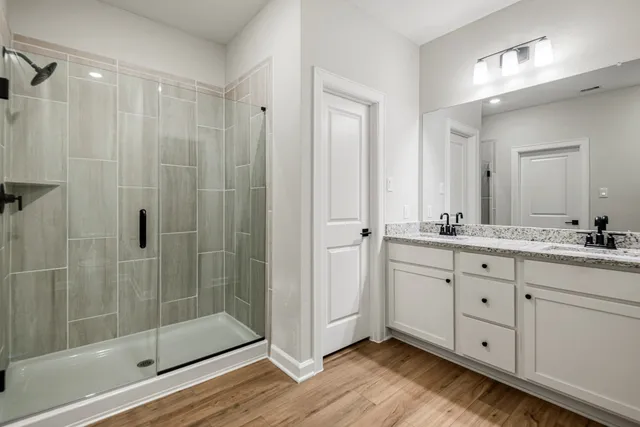 a bathroom with a double vanity sink mirror and shower