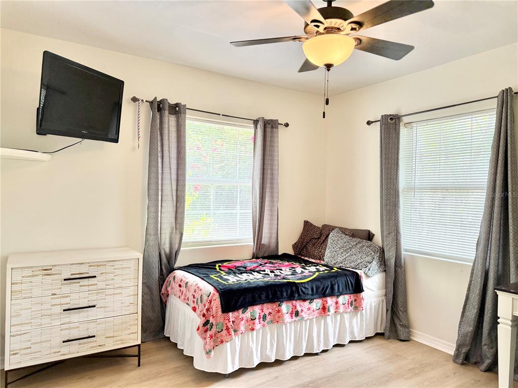 5846 Wyoming Avenue New Port Richey, FL 34652 - Photo 28 of 47 a bedroom with a bed a flat screen tv and a chandelier