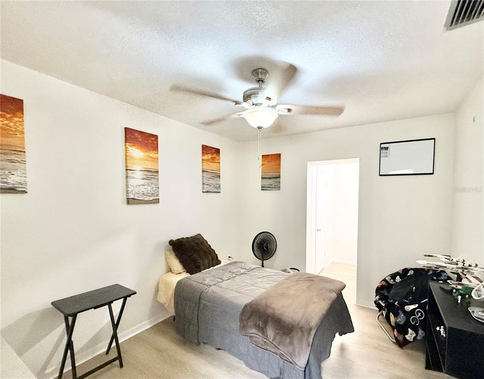 5846 Wyoming Avenue New Port Richey, FL 34652 - Photo 32 of 47 a spacious bedroom with a bed and a chandelier