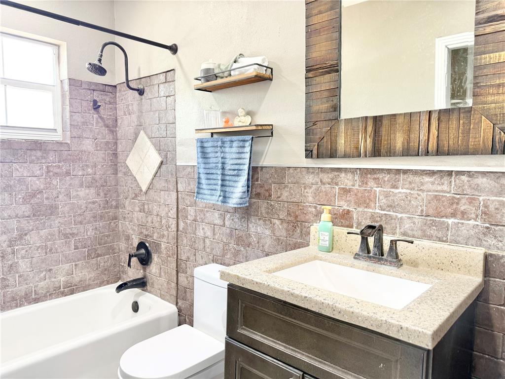 5846 Wyoming Avenue New Port Richey, FL 34652 - Photo 36 of 47 a bathroom with a granite countertop sink a toilet and bathtub