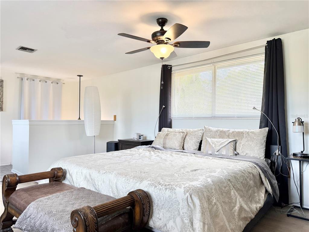 5846 Wyoming Avenue New Port Richey, FL 34652 - Photo 40 of 47 a bedroom with a bed and a chandelier