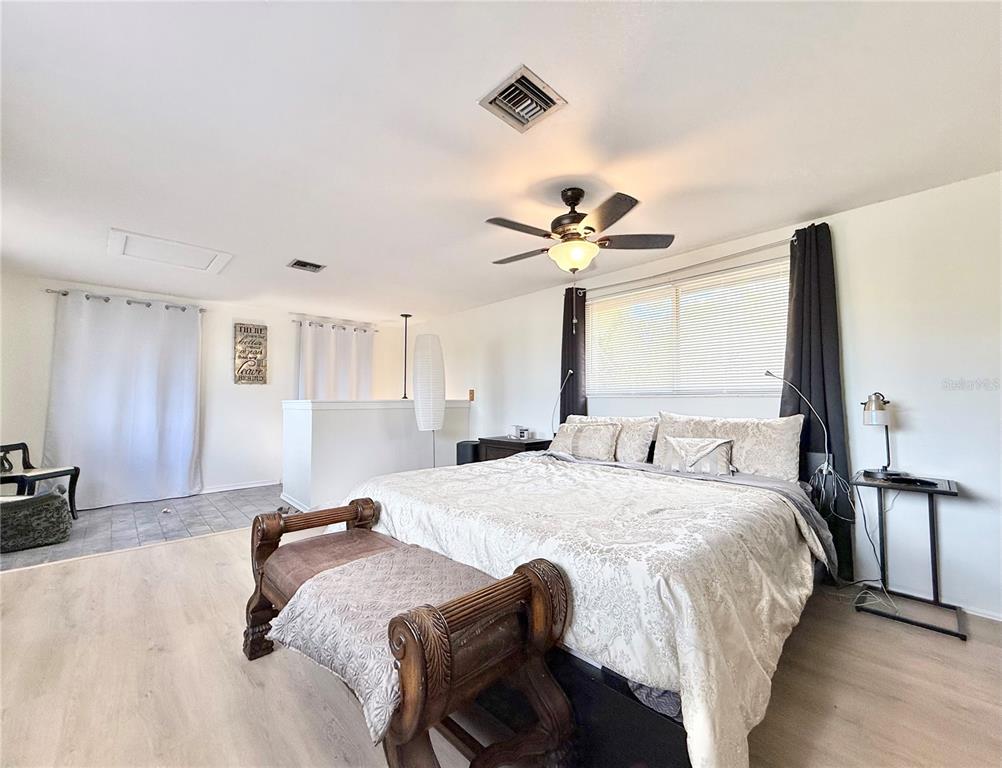 5846 Wyoming Avenue New Port Richey, FL 34652 - Photo 41 of 47 a spacious bedroom with a bed and a chandelier