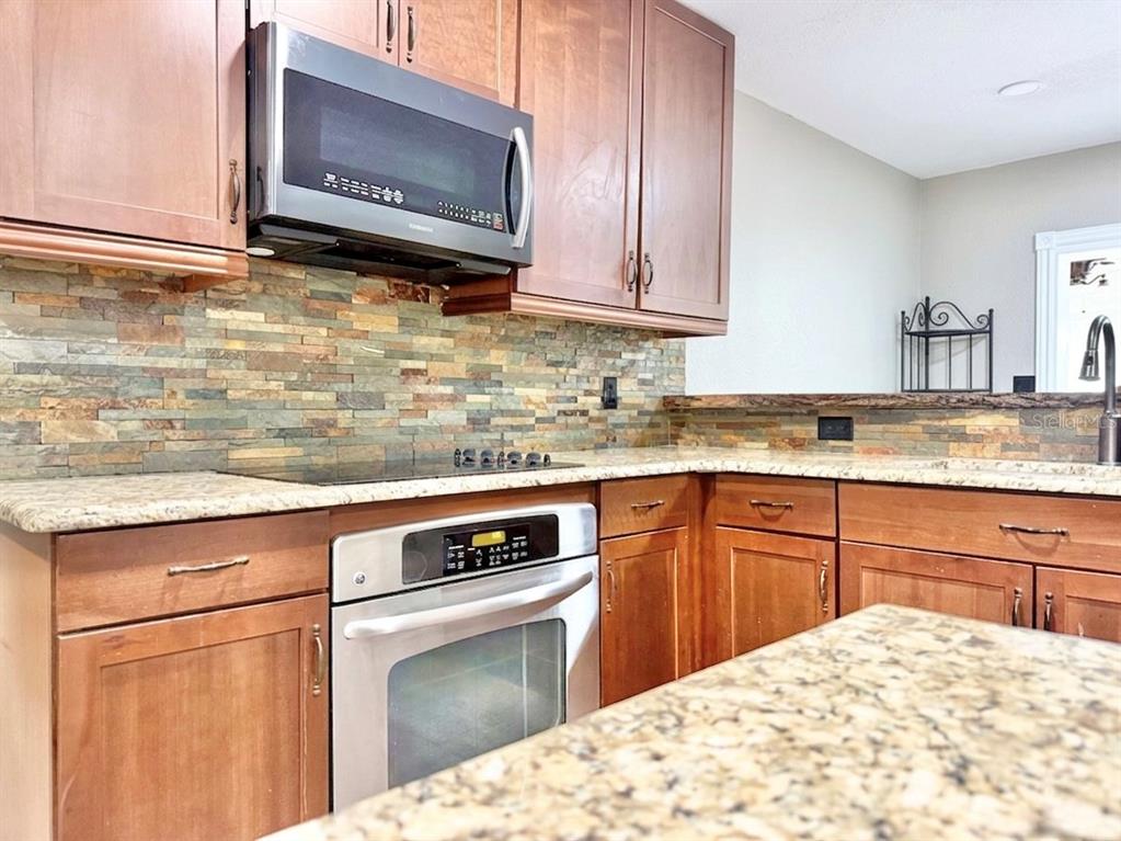 5846 Wyoming Avenue New Port Richey, FL 34652 - Photo 5 of 47 a kitchen with stainless steel appliances granite countertop a sink stove and microwave