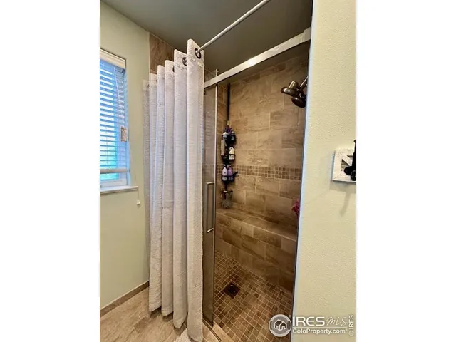 a bathroom with a shower and a glass door