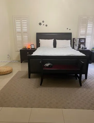 a bed sitting in a bedroom next to a window