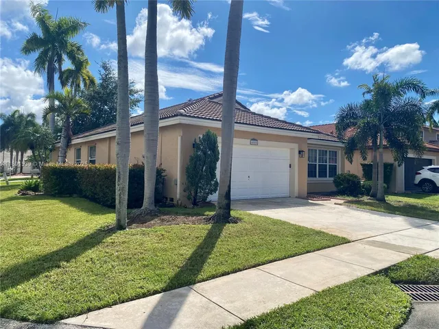 a view of a house with backyard and a tree