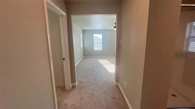 a view of a hallway with wooden floor and a living room