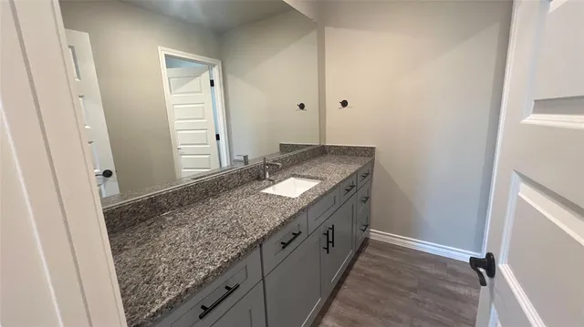 a bathroom with a granite countertop sink and a mirror