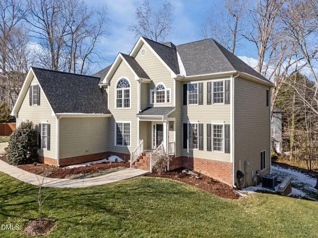 a kitchen with stainless steel appliances granite countertop a refrigerator a oven a dining table and chairs with wooden floor