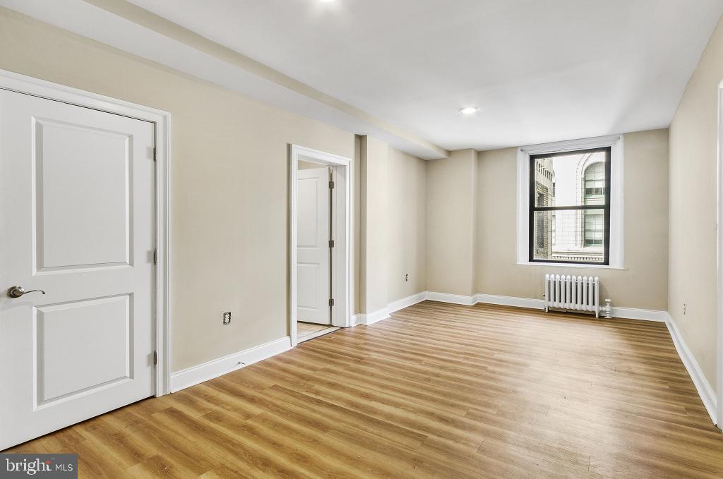 1229 Chestnut Street, Unit 209 Philadelphia, PA 19107 - Photo 11 of 19 a view of empty room with wooden floor and fan