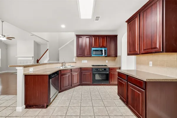 a kitchen with stainless steel appliances granite countertop a stove and a sink