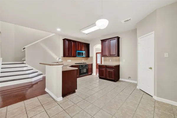 a view of a livingroom with wooden floor a fireplace and a ceiling fan