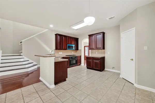 a view of a livingroom with wooden floor fireplace and a ceiling fan