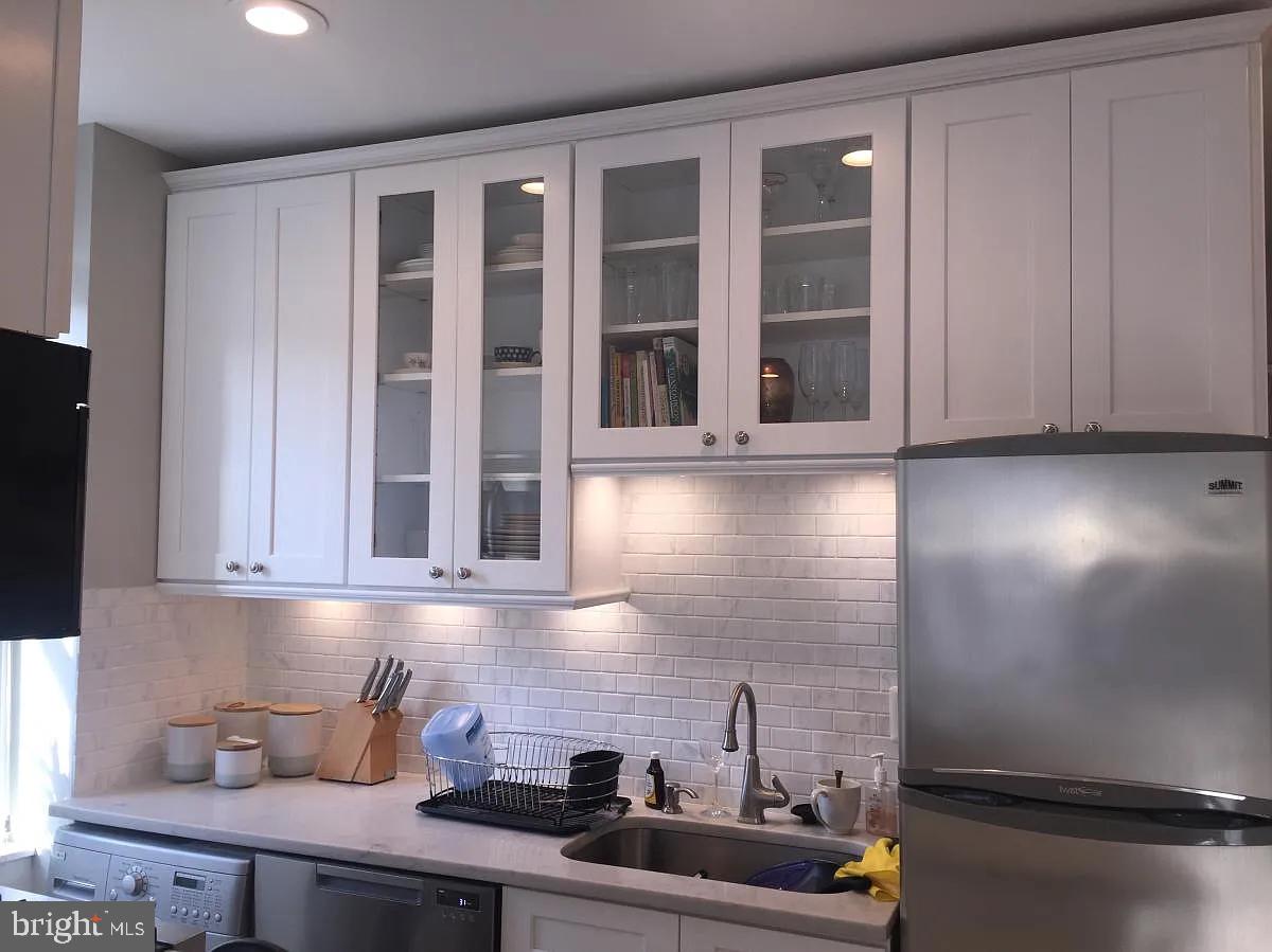 2410 20th Street Northwest, Unit 204 Washington, DC 20009 - Photo 1 of 8 a kitchen with stainless steel appliances white cabinets and a window