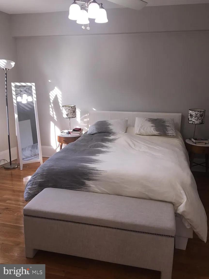 2410 20th Street Northwest, Unit 204 Washington, DC 20009 - Photo 4 of 8 a bedroom with a bed and a chandelier