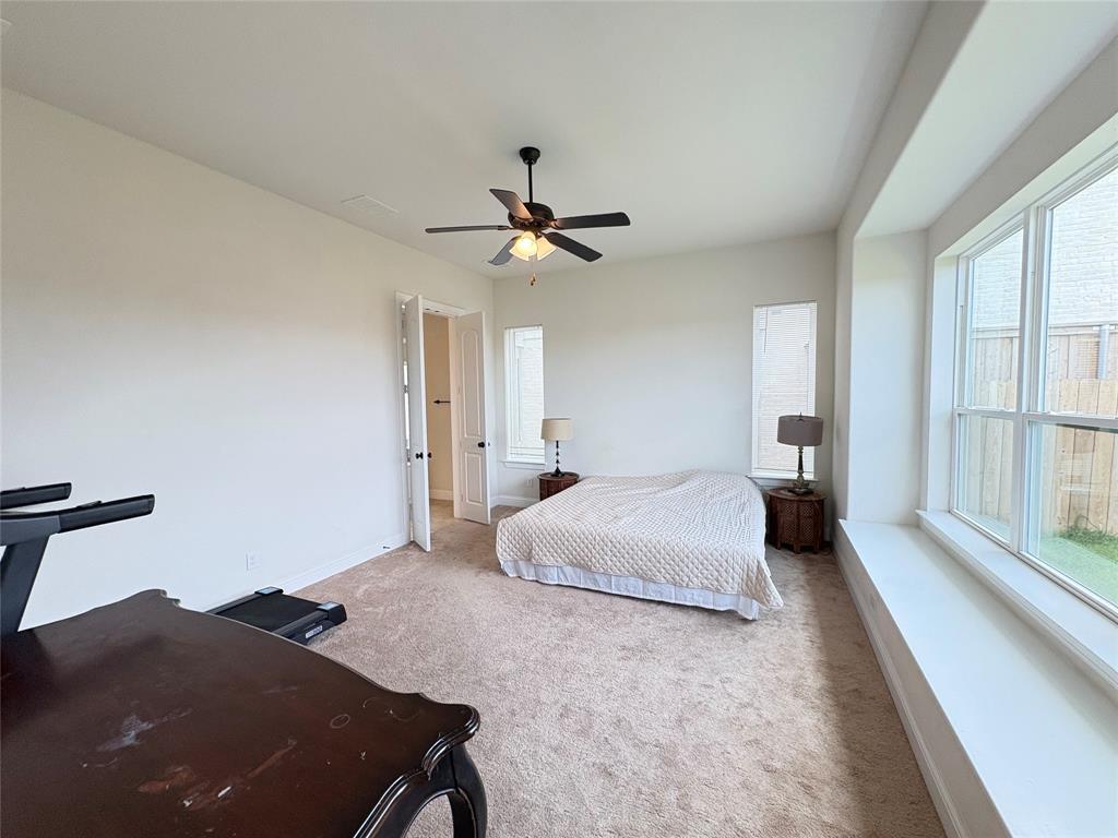 323 Butternut Way Irving, TX 75063 - Photo 16 of 32 a bedroom with a large bed and a ceiling fan