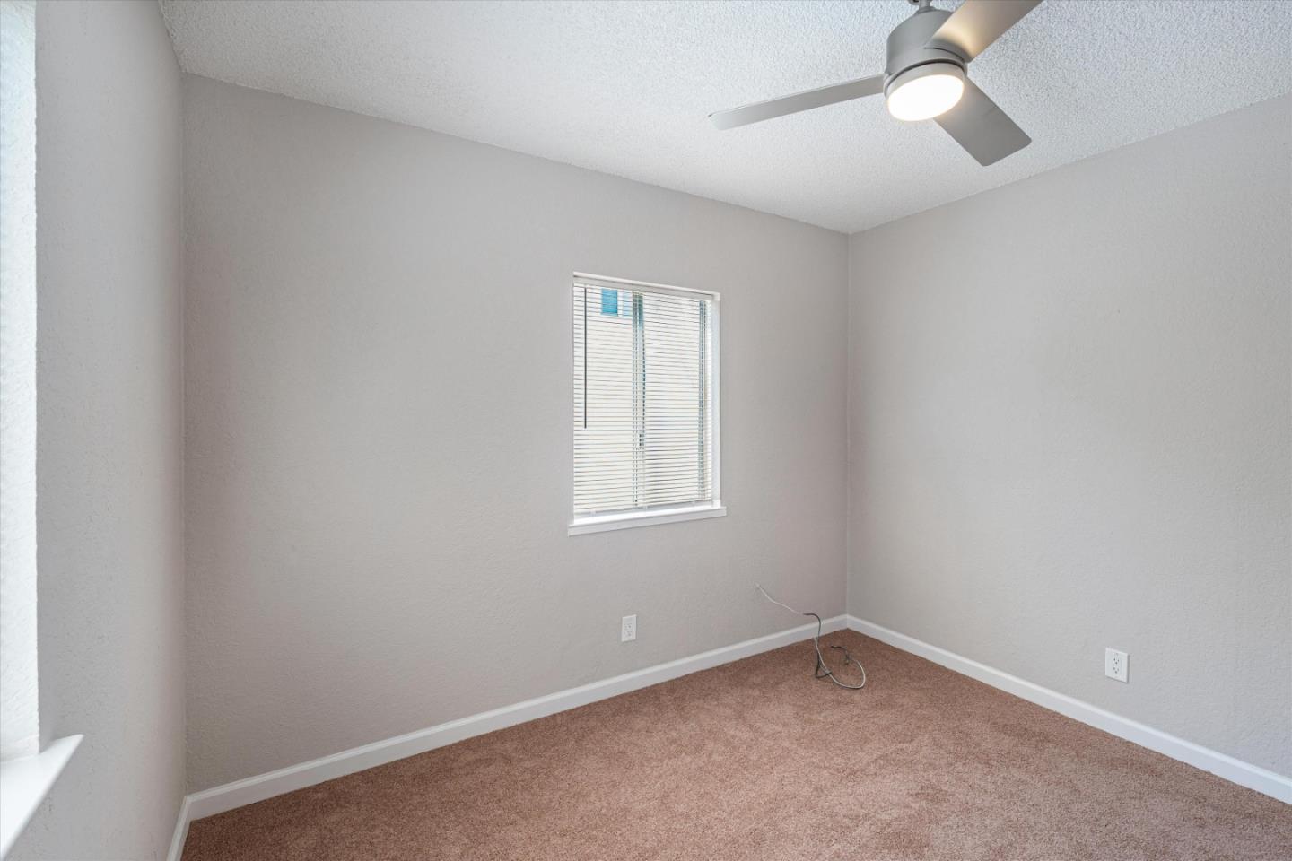 149 Covena Avenue Modesto, CA 95354 - Photo 13 of 24 an empty room with a window and ceiling fan