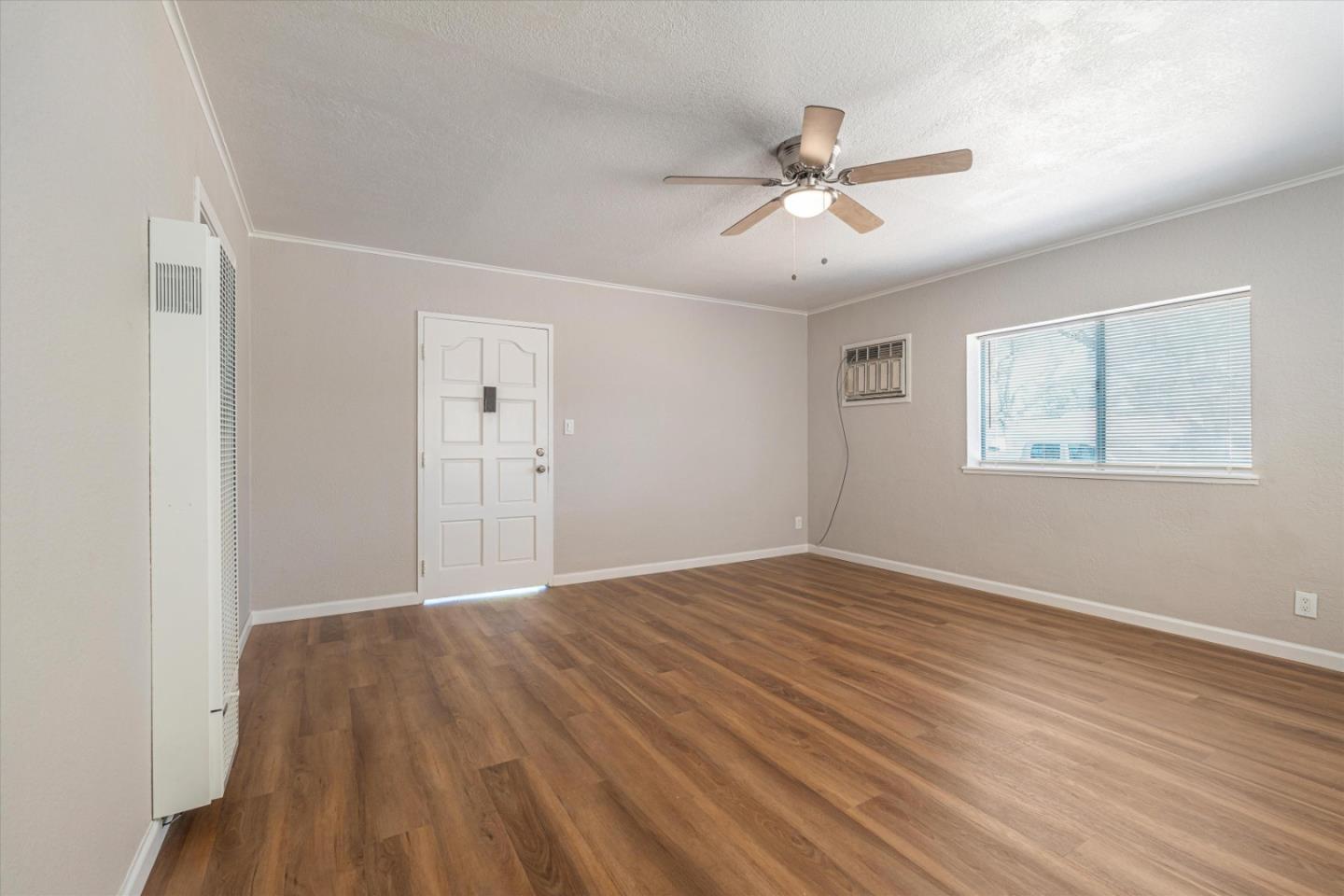 149 Covena Avenue Modesto, CA 95354 - Photo 4 of 24 a view of an empty room with wooden floor and a ceiling fan