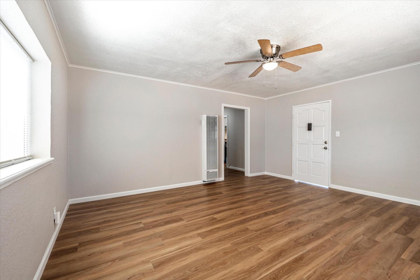 149 Covena Avenue Modesto, CA 95354 - Photo 6 of 24 a view of an empty room with wooden floor and a window