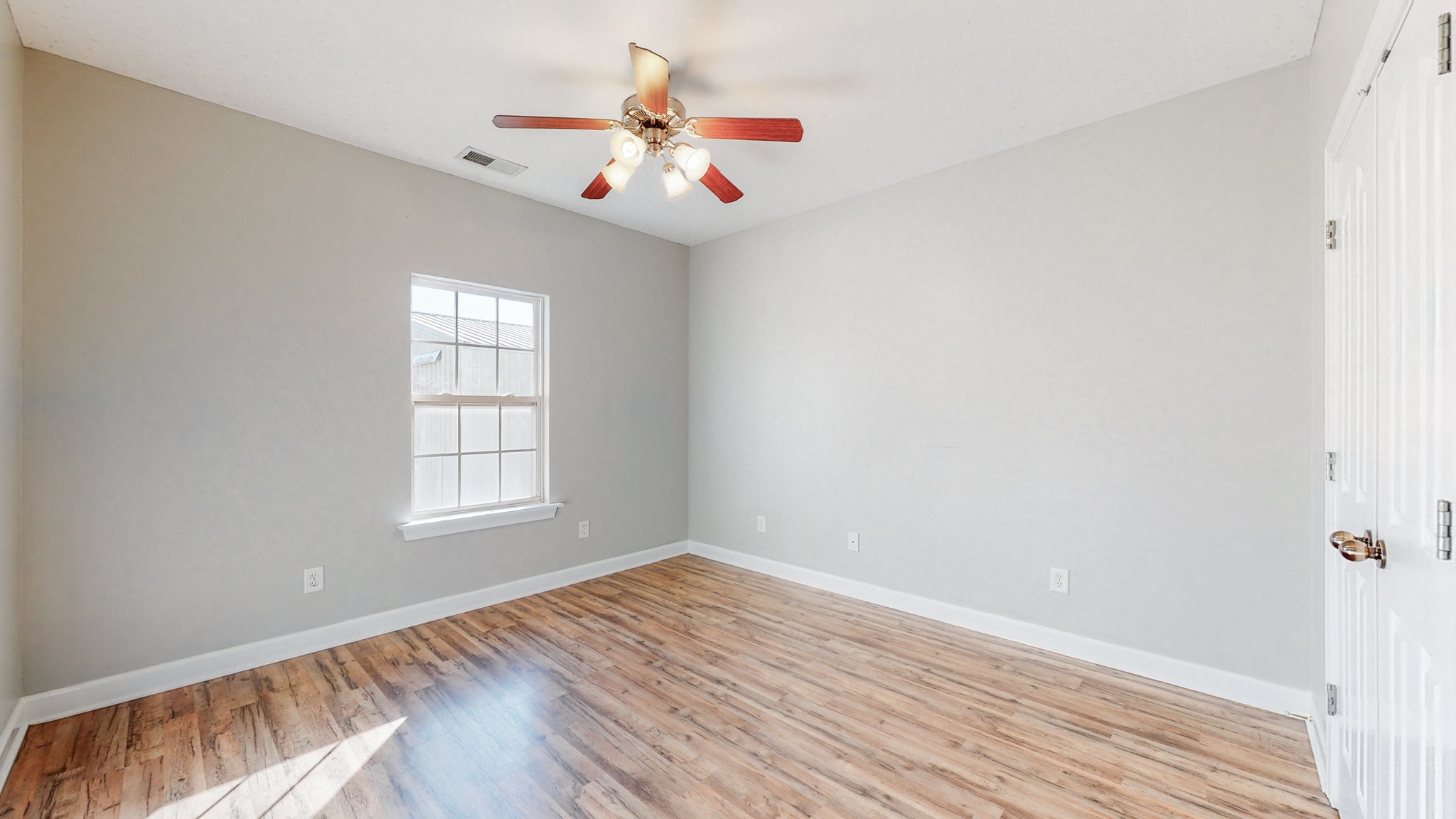 6023 Murfreesboro Road Lebanon, TN 37090 - Photo 25 of 42 an empty room with wooden floor chandelier fan and windows