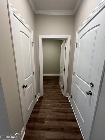 a view of a hallway with wooden floor and stairs