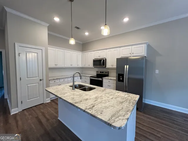 a kitchen with kitchen island a counter top space appliances and cabinets