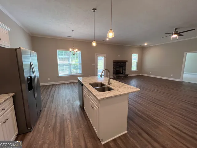 a kitchen with stove and wooden floor