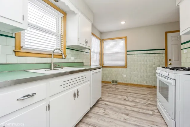 a kitchen with a sink cabinets stainless steel appliances and a window