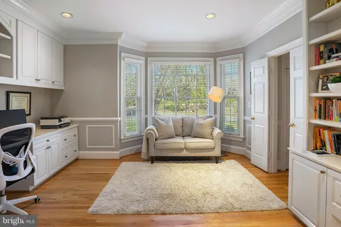 a living room with furniture hard wood floor and a book shelf