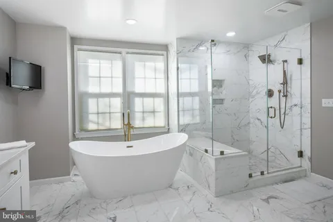 a white bath tub sitting next to a shower