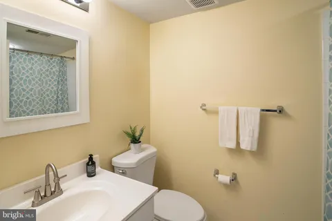 a bathroom with a sink a toilet and mirror
