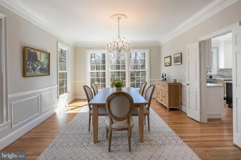 a dining room with furniture a chandelier and wooden floor