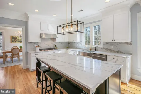 a kitchen with granite countertop a table chairs stove a sink dishwasher and cabinets with wooden floor