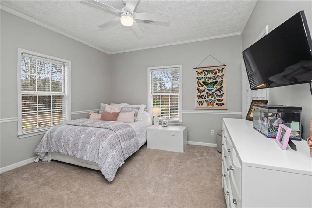 696 Highway 18 Barnesville, GA 30204 - Photo 12 of 57 a bed room with a bed a television and a large window