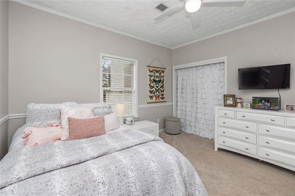 696 Highway 18 Barnesville, GA 30204 - Photo 13 of 57 a bedroom with a bed a flat screen tv and a chandelier